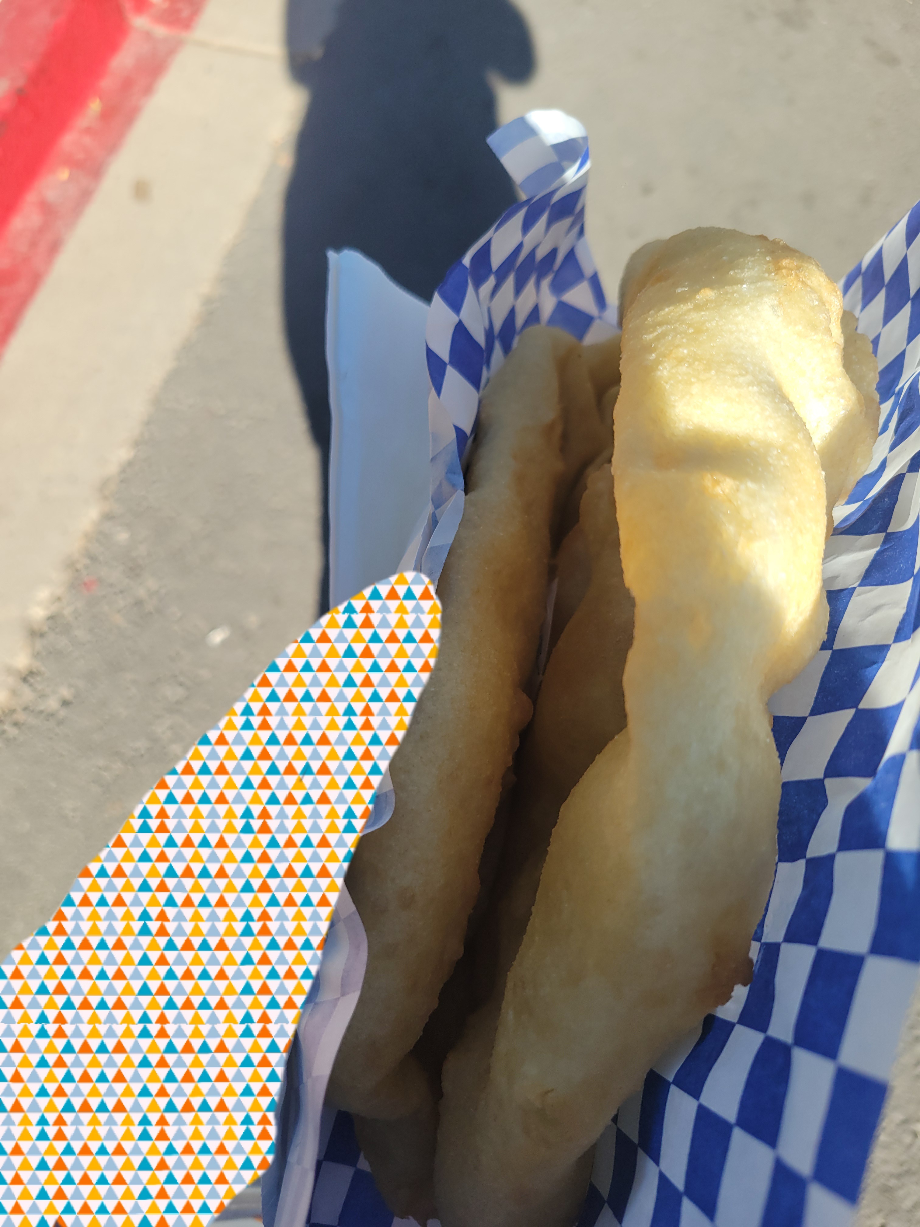 Hand holds plate of fried bread in half.